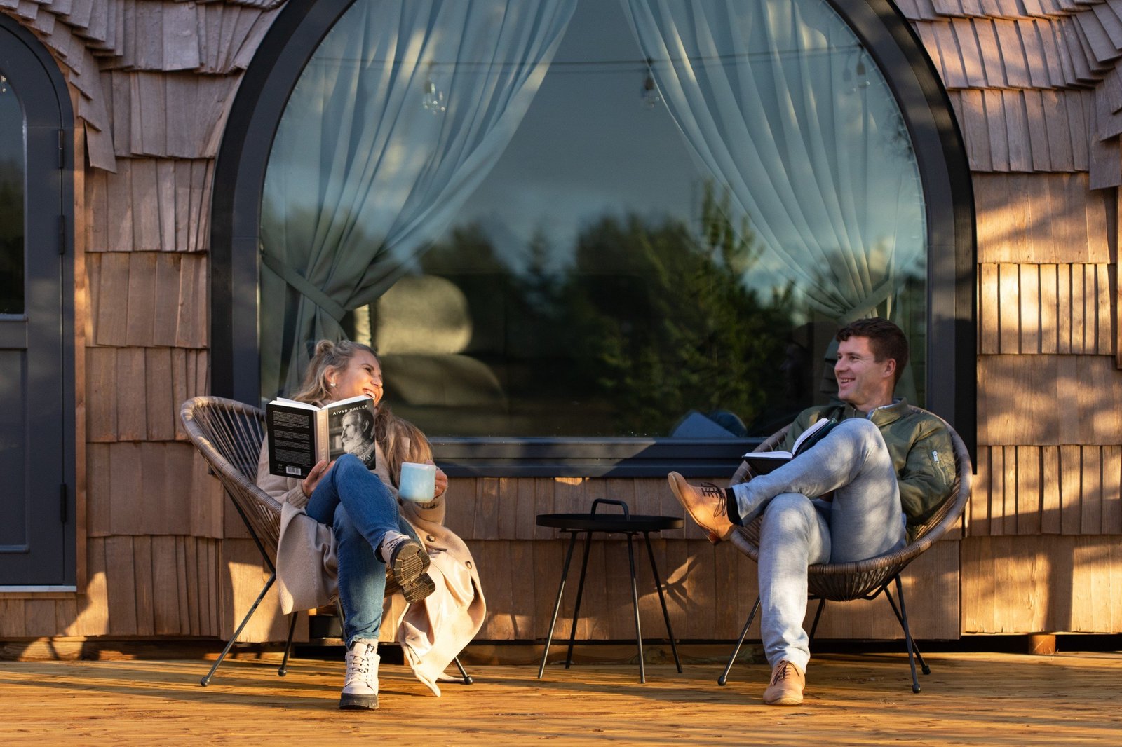 People relaxing in front of a cabin